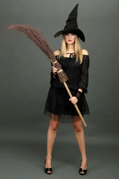 Halloween witch with broom on gray background — Stock Photo, Image