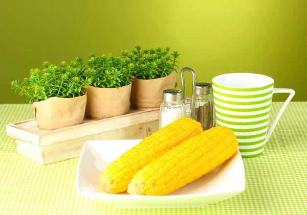 Gotowanej kukurydzy i kwiatów na zielonym tle — Zdjęcie stockowe
