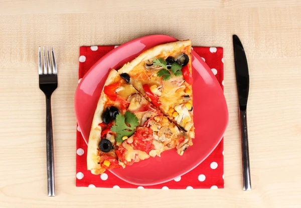 Läcker bit pizza på färg plattan närbild på träbord — Stockfoto