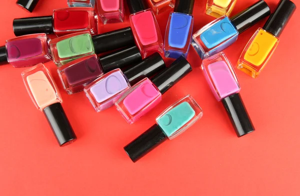 Group of bright nail polishes, on red background — Stock Photo, Image
