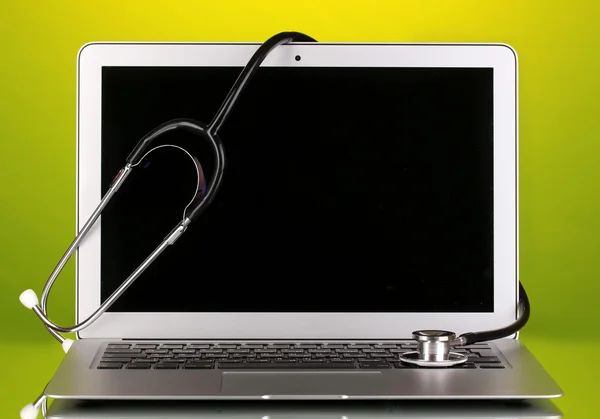 Silver notebook with a stethoscope on yellow background with reflection clo — Stock Photo, Image