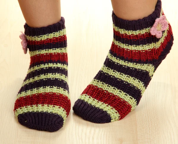 Beine weiblich in gestreiften Socken auf Laminatboden — Stockfoto