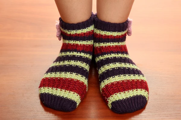 Beine weiblich in gestreiften Socken auf Laminatboden — Stockfoto