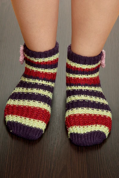 Beine weiblich in gestreiften Socken auf Laminatboden — Stockfoto