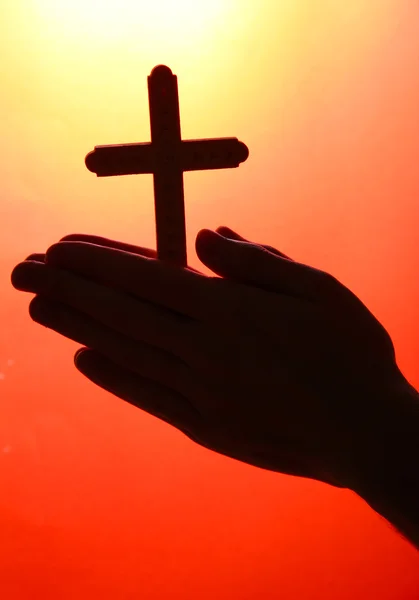 Hombre manos con crucifijo, sobre fondo rojo — Foto de Stock