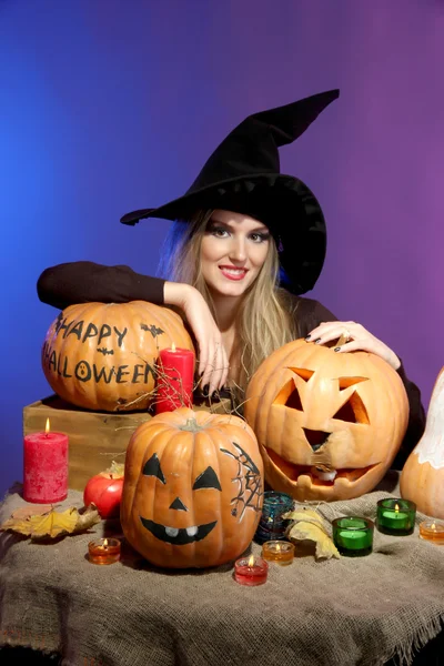 Bruja de Halloween con calabazas sobre fondo de color —  Fotos de Stock