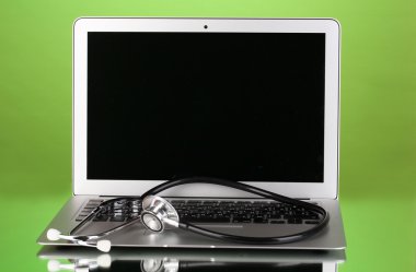 yansıma yeşil zemin üzerine bir stetoskop ile gümüş defter