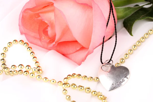 Tender pink rose with heart pendant — Stock Photo, Image