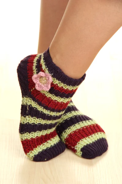 Piernas femeninas en calcetines a rayas en suelo laminado —  Fotos de Stock