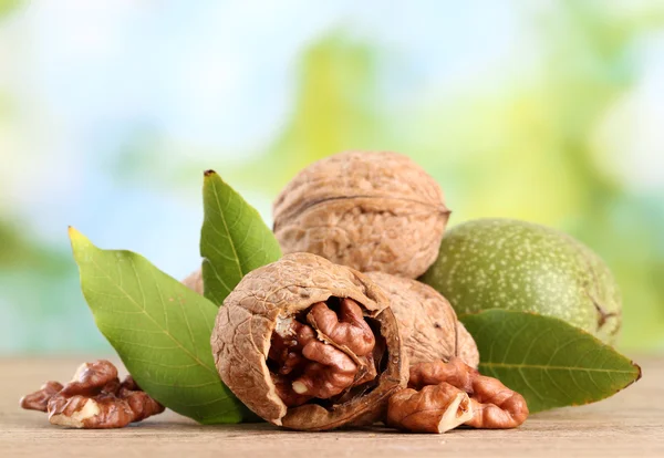 Walnuts with green leaves, on green background — Stock Photo, Image