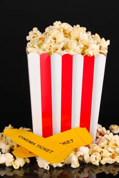 Popcorn z bilety do kina na czarnym tle — Zdjęcie stockowe