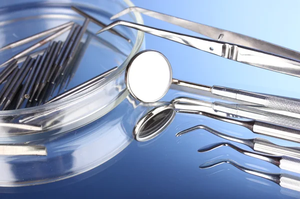 Set di strumenti dentali per la cura dei denti isolati su sfondo blu — Foto Stock