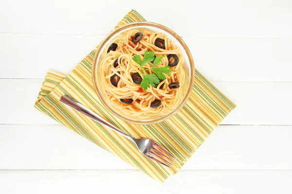 Italian spaghetti in glass bowl on wooden table — Stock Photo, Image