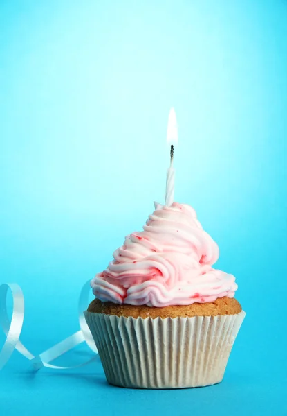 Gustoso cupcake di compleanno con candela, su sfondo blu — Foto Stock