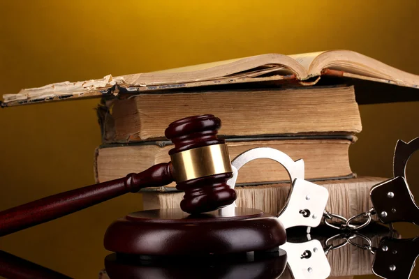 Gavel, handcuffs and book on law on yellow background — Stock Photo, Image