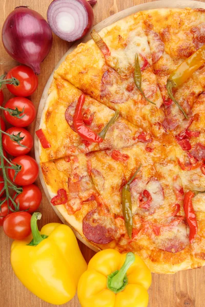 Sabrosa pizza de pepperoni con verduras sobre tabla de madera sobre fondo de madera —  Fotos de Stock