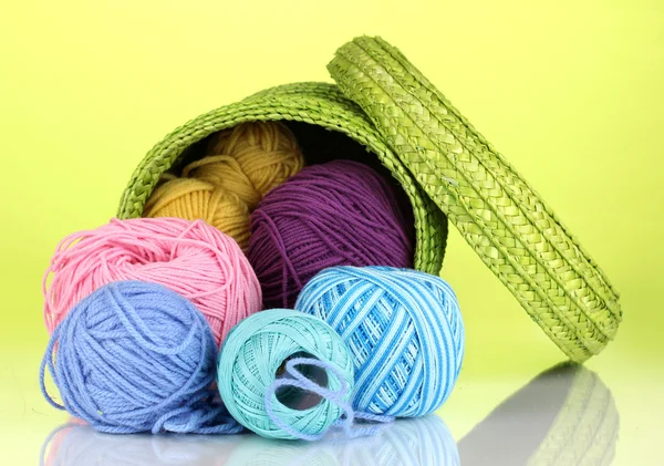 Colorful yarn for knitting in green basket on green background — Stock Photo, Image