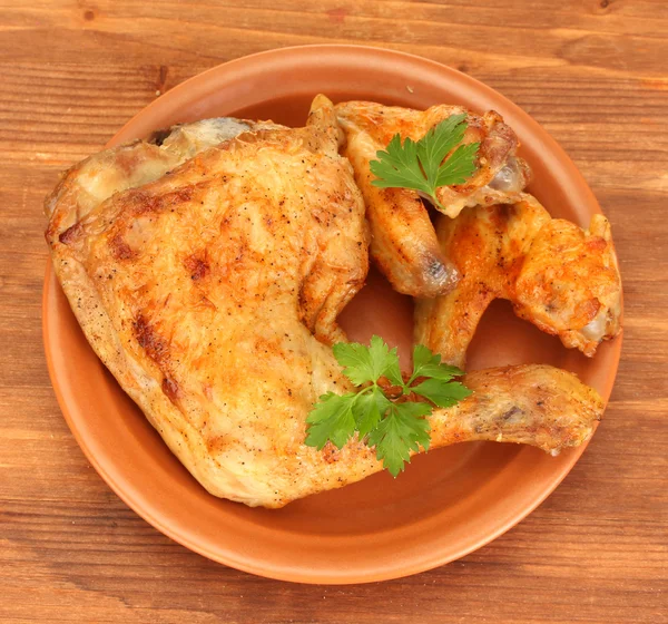 Roasted chicken wings and leg with parsley in the plate on wooden backgroun — Stock Photo, Image