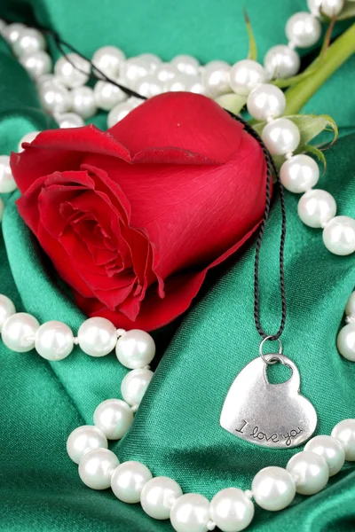 Beautiful red rose with heart pendant — Stock Photo, Image