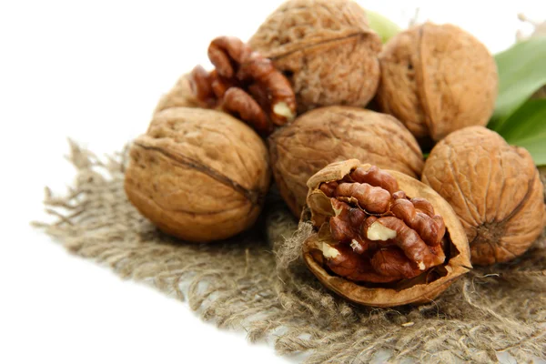 Nueces con hojas verdes sobre arpillera, aisladas sobre blanco —  Fotos de Stock