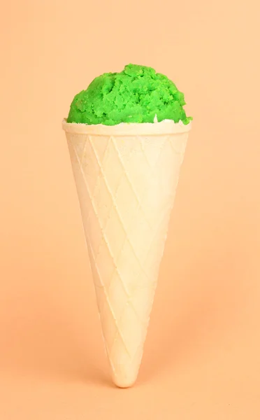 Scoop of the kiwi ice cream in the waffle cone on coral background — Stock Photo, Image