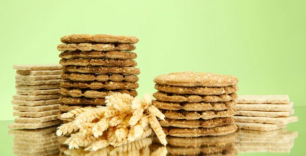 Leckeres Knäckebrot und Ohren, auf grünem Hintergrund — Stockfoto