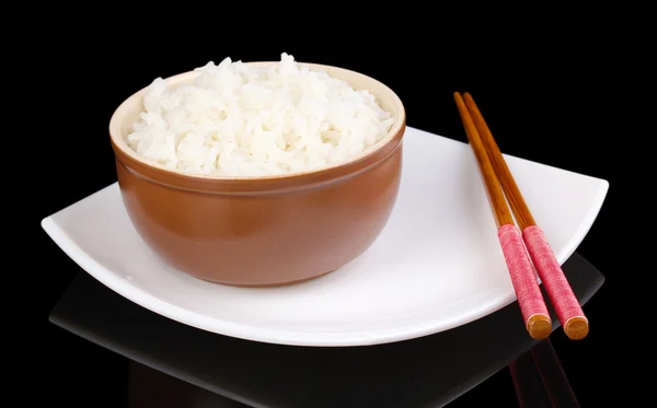 Bowl of rice and chopsticks on plate isolated on black — Stock Photo, Image