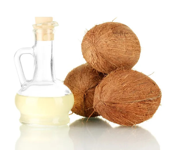 Decantador con aceite de coco y cocos aislados en blanco — Foto de Stock