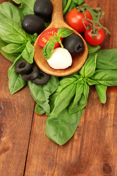 Queso mozzarella con verduras en cuchara de madera sobre fondo de madera clos — Foto de Stock