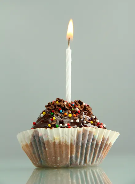 Tasty birthday cupcake with candle, on grey background — Stock Photo, Image