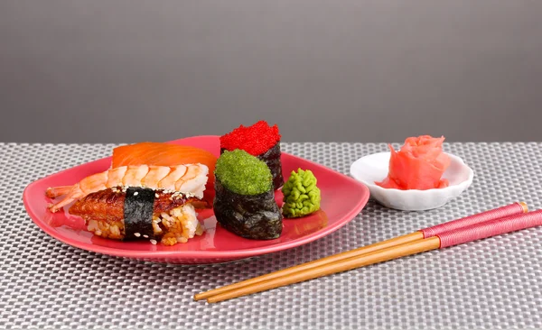 Délicieux sushi servi sur assiette sur fond gris — Photo