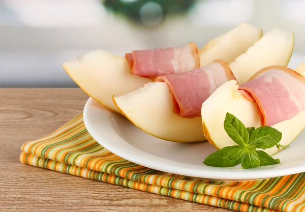 Parma ham and melon, on wooden table — Stock Photo, Image