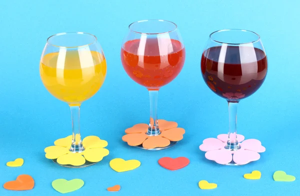 Cocktails colorés avec décor lumineux pour verres sur fond bleu — Photo