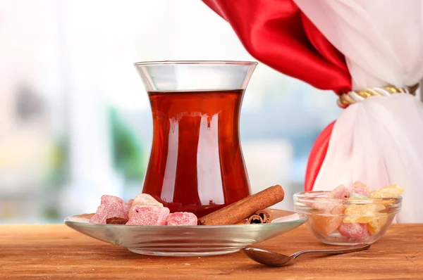 Glass of Turkish tea and rahat lokum, on wooden table — Stock Photo, Image