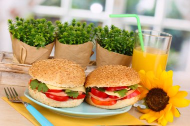 ahşap masa penceresinin arka plan üzerinde renkli plaka üzerinde lezzetli sandviçler