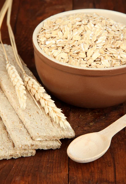 Oat flakes in brown bowl on the table — Stock Photo, Image