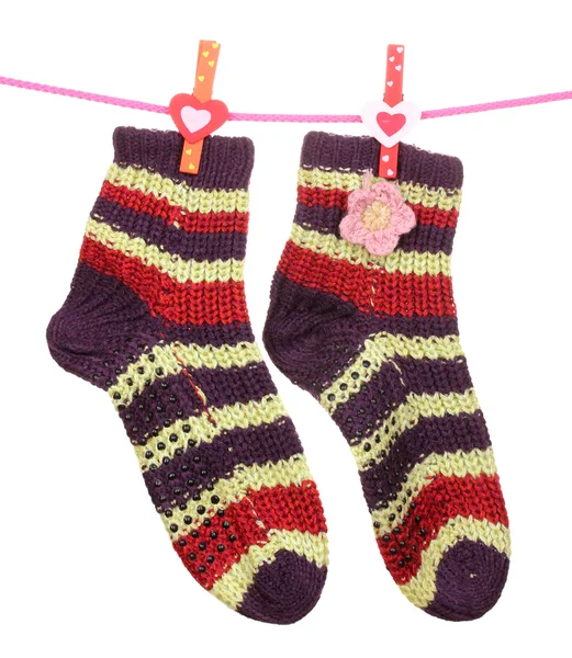 Paar gestrickte gestreifte Socken, die an einem Seil hängen, isoliert auf weiß — Stockfoto