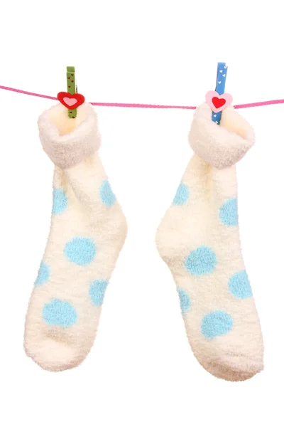 Paar Socken mit Tupfen, die an einem Seil hängen, isoliert auf weiß — Stockfoto