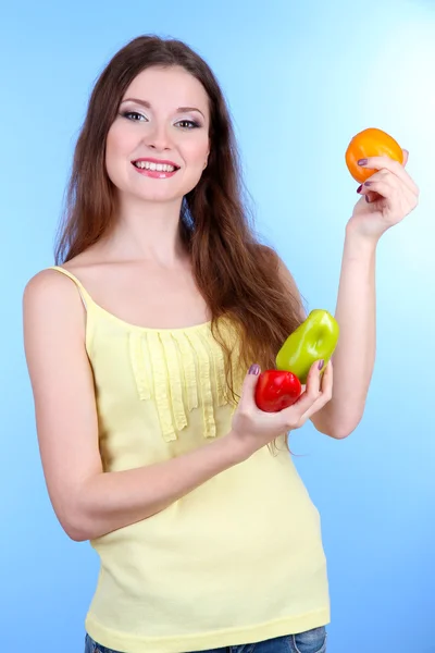 Mulher bonita com pimenta no fundo azul — Fotografia de Stock