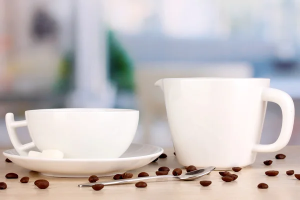 Secangkir kopi yang kuat dan krim manis di atas meja kayu di latar belakang kamar — Stok Foto