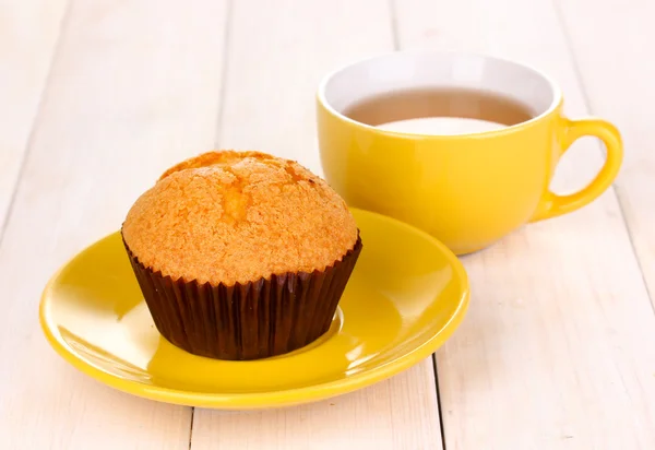 Fresh muffin with tea on wooden background — Stock Photo, Image