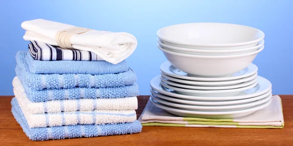 Toallas de cocina con platos sobre fondo azul primer plano — Foto de Stock