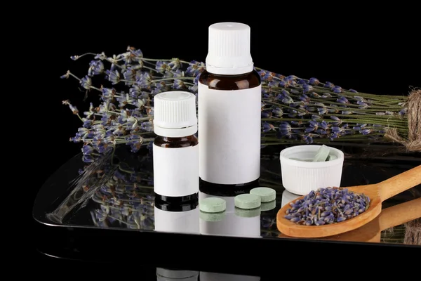 Frascos de medicamentos y hierbas sobre fondo negro. concepto de homeopatía —  Fotos de Stock
