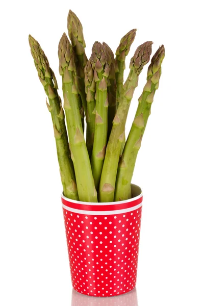 Fresh asparagus in colorful pot isolated on white — Stock Photo, Image