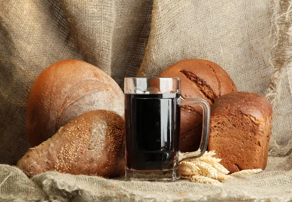 Tankard van kvas en rogge brood met oren, op jute achtergrond — Stockfoto