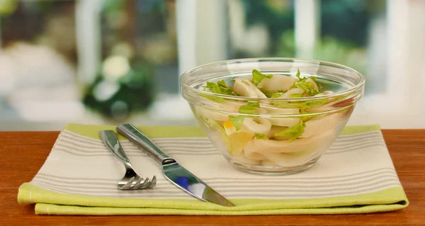 Salat aus Tintenfischringen, Zitrone und Salat in einer Glasschüssel auf einem Holztisch — Stockfoto