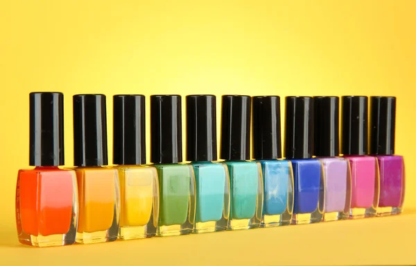 Groupe de vernis à ongles lumineux, sur fond jaune — Photo