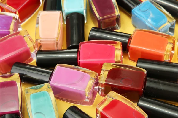 Group of bright nail polishes, on yellow background — Stock Photo, Image