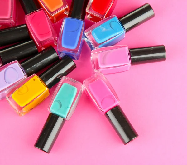 Group of bright nail polishes, on pink background — Stock Photo, Image