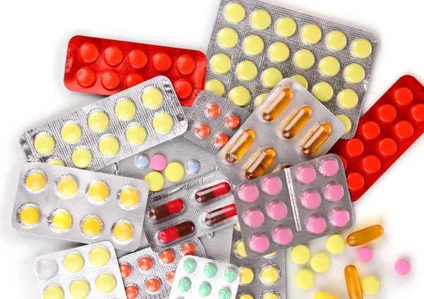 Cápsulas y pastillas envasadas en ampollas aisladas en primer plano blanco — Foto de Stock